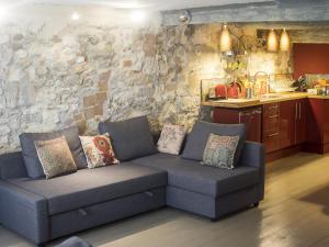 a living room with a couch and a stone wall at Appartements La Croix - Hyper Centre - Palais des Papes et Pont d'Avignon - WiFi in Avignon