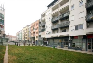 a row of apartment buildings with a lawn in front at NFM Apartman in Osijek