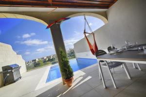 a dining room with a view of a swimming pool at Hemda no 3 in Birbuba