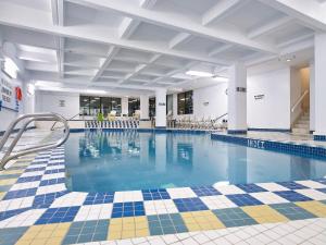a large swimming pool with blue water in a building at Wyndham Edmonton Hotel and Conference Centre in Edmonton