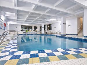 ein großer Pool mit blauem Wasser in einem Gebäude in der Unterkunft Wyndham Edmonton Hotel and Conference Centre in Edmonton