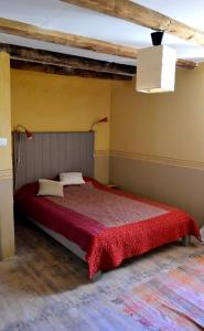 una camera da letto con un grande letto con una coperta rossa di La Ferme du Crouzet a Rimeize
