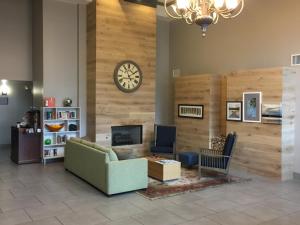 a lobby with a couch and a clock on a wall at Country Inn & Suites by Radisson, Louisville East, KY in Louisville