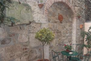 a stone wall with a table and a plant at Piccola corte in Ascoli Piceno