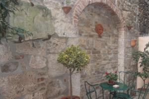 una pared de piedra con una mesa y una planta en Piccola corte, en Ascoli Piceno