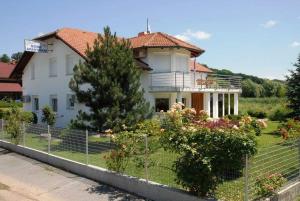 een wit huis met een hek ervoor bij Apartments Villa Split in Krapinske Toplice