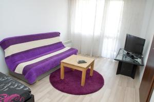 salon z fioletową kanapą i stołem w obiekcie Apartment Medical University w mieście Plewen