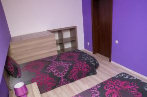 a small bedroom with a bed with purple walls at Apartment Medical University in Pleven