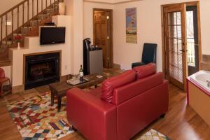 a living room with a red couch and a fireplace at Farmers Guest House in Galena