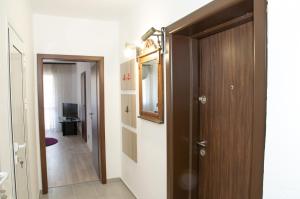 a room with a door and a mirror and a hallway at Apartment Medical University in Pleven
