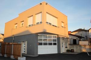 a house with a garage door at Apartmani Ivana in Bjelovar