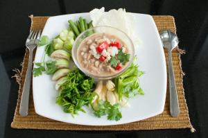 a plate of food with a bowl of soup and vegetables at Kasemsarn Hotel Chanthaburi in Chanthaburi