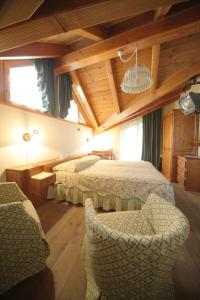 Hotel Posta في Issime: غرفة نوم بسريرين وكراسي في غرفة