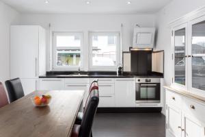 uma cozinha com armários brancos e uma mesa de madeira em Sarnen Apartment 1 em Sarnen