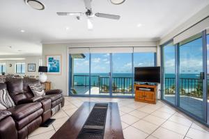 a living room with a couch and a flat screen tv at Alexandra on the Pacific in Mooloolaba