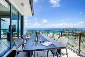 a table on a balcony with a view of the ocean at Alexandra on the Pacific in Mooloolaba