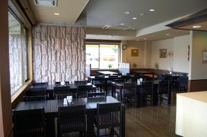 a restaurant with tables and chairs and a large window at Hotel Route-Inn Court Karuizawa in Miyota