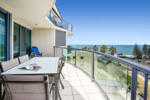 a balcony with a table and chairs and the ocean at Alexandra on the Pacific in Mooloolaba