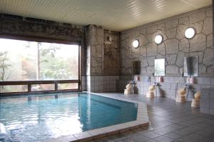 a large swimming pool with a large window in a room at Hotel Route-Inn Court Karuizawa in Miyota