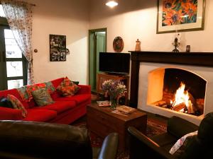 a living room with a red couch and a fireplace at Dingup House in Manjimup
