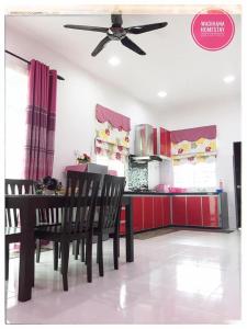 uma cozinha com uma mesa e cadeiras e uma ventoinha de tecto em Wadihana Homestay em Kangar