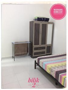 a bedroom with two beds and a dresser at Wadihana Homestay in Kangar