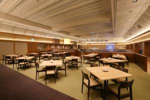 a restaurant with tables and chairs in a room at Kurobe Unazukionsen Yamanoha in Kurobe