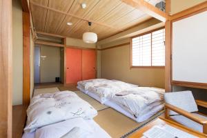 two beds in a room with a whiteboard at Alpine Villa Nozawa in Nozawa Onsen +67 photos