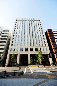 東京にある秋葉原ワシントンホテルの目の前を歩く人々のいる高い建物