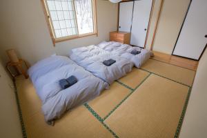 a bed in a room with two pillows on it at Nozawa House in Nozawa Onsen