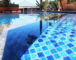 a swimming pool with blue tiles on it at Sinar Sport Hotel in Bengkulu