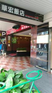 frente a una tienda con un banco verde frente a un edificio en Hwa Hong Hotel, en Kaohsiung