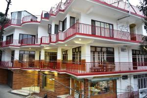 an external view of a building with red balconies at Hotel Akash in McLeod Ganj