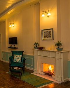 a living room with a fireplace and a chair at Ging Tea House in Darjeeling
