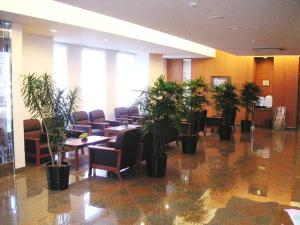 un vestíbulo con mesas y macetas en un edificio en Hotel Route-Inn Nakatsu Ekimae, en Nakatsu