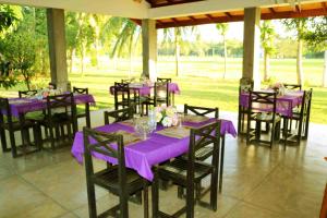 a group of tables and chairs with purple table cloth at Manel Guest House in Polonnaruwa