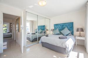 a bedroom with two beds and a large mirror at 3 Canterbury Square in Cape Town