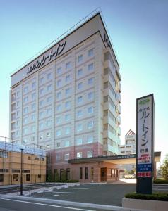 a large building with a sign in front of it at Hotel Route-Inn Yukuhashi in Yukuhashi