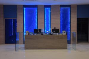 a lobby with a reception desk with blue lights at Blue Rabbit Hotel in Chanthaburi