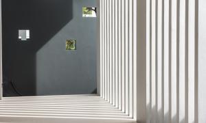 een gang met een witgestreepte muur en een spiegel bij Blue Rabbit Hotel in Chanthaburi +36 foto's