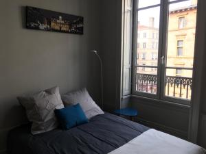 - une chambre avec un lit et une grande fenêtre dans l'établissement Celect'in Lyon, à Lyon