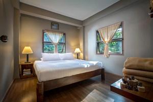 une chambre avec un lit et deux fenêtres dans l'établissement Khaokhoherbary OrganicFarm&Resort, à Khao Kho