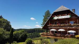 a building with umbrellas and flowers on it at Schwarzwaldgasthaus Salenhof in Titisee-Neustadt