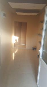 an empty room with a white floor and a light at Pestani Apartment in Peštani