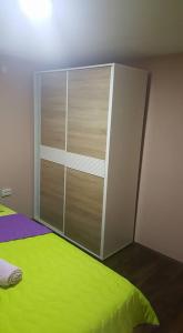 a bedroom with a green bed and a closet at Pestani Apartment in Peštani