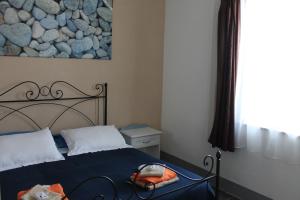 a bedroom with a bed and a rock wall at B&B Stella Marina in Manfredonia