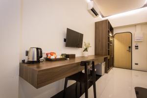 a room with a desk with a microwave and a television at BearPacker Patong Hostel - SHA Extra Plus in Patong Beach