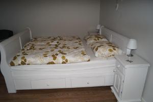 a bedroom with a white bed and a nightstand at Bed en Breakfast Donkersvoort in Benk en Donk