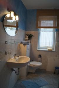 a bathroom with a sink and a toilet and a mirror at Ferienhaus Käpt´n Moritz in Karlshagen +25 photos