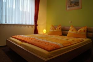 a bedroom with a bed with orange sheets and a window at Ferienhaus Käpt´n Moritz in Karlshagen